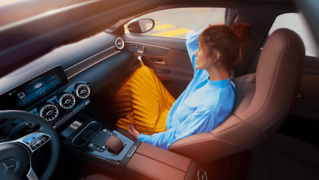 Photo d'une femme à l'intérieur d'un véhicule Mercedes-Benz flambant neuf, en cuire et full option. 