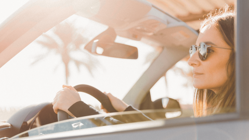 Photo d'une femme conduisant une SMART en plein soleil. 