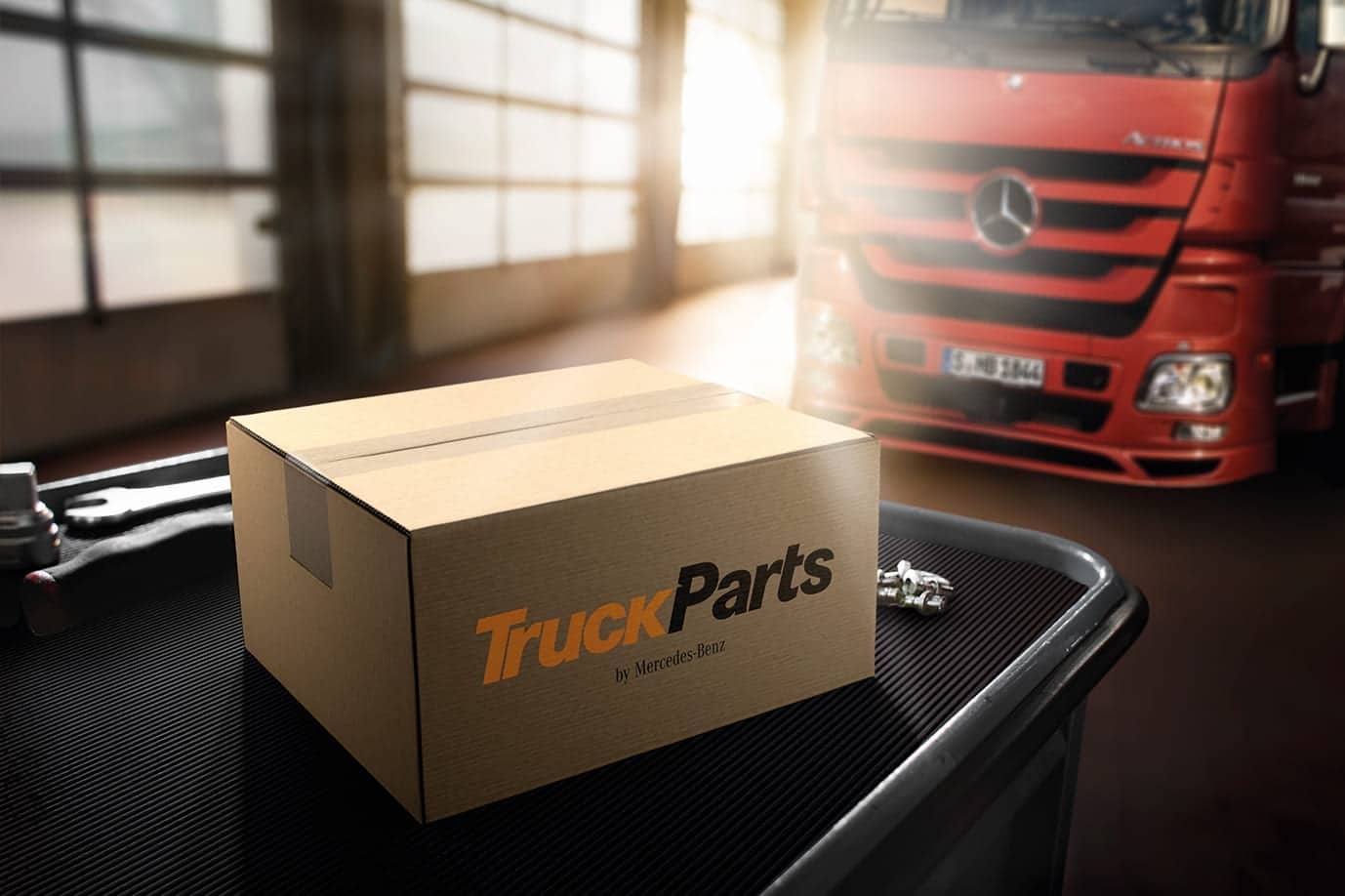 Colis Mercedes-Benz TruckParts devant un camion Actros rouge — pièces détachées poids lourds